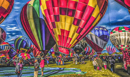Colorful hot air balloons at a Albuquerque International Balloon Fiesta with people around.