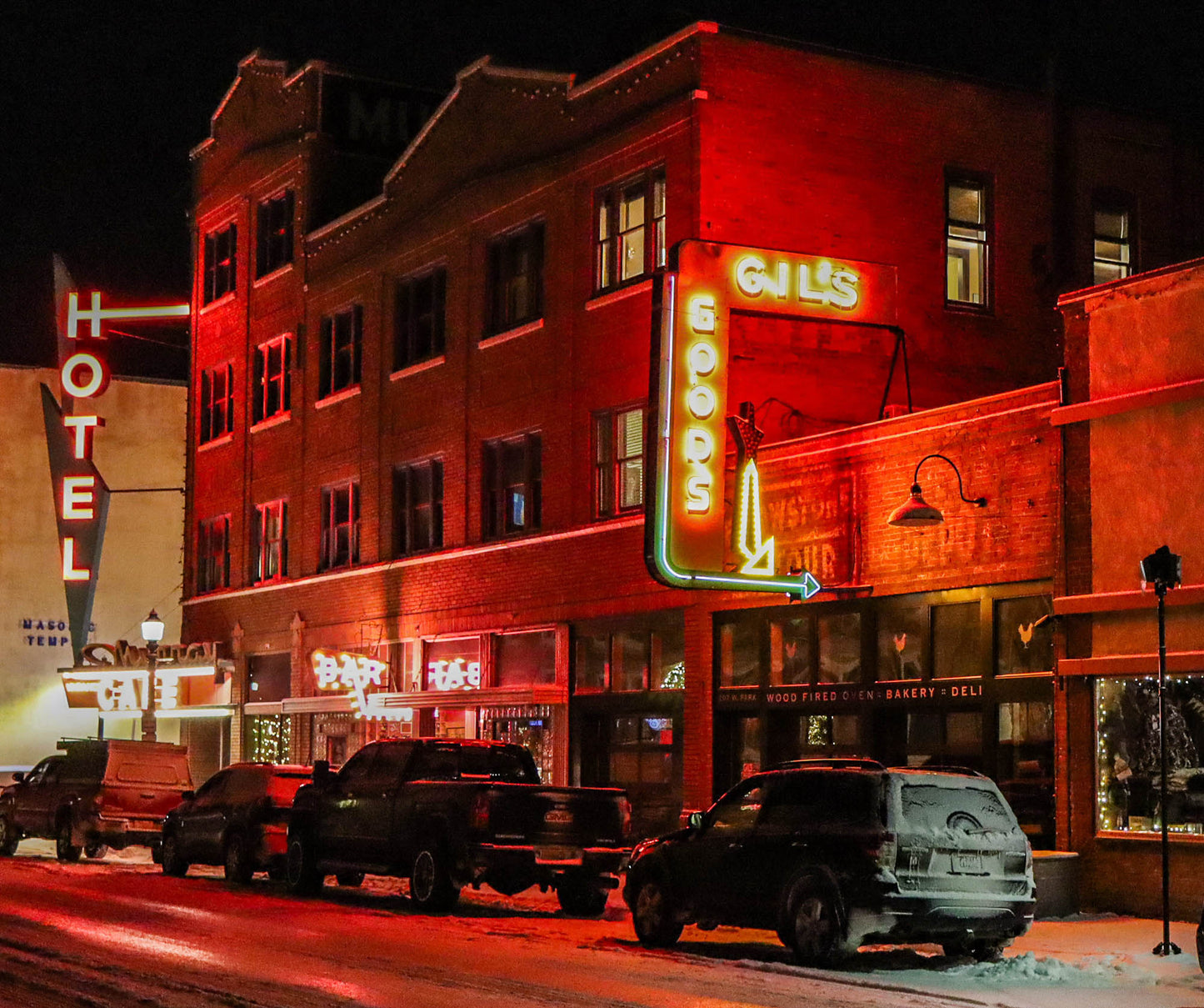 Neon-lit building with 'Gill's' sign on a city street at night.