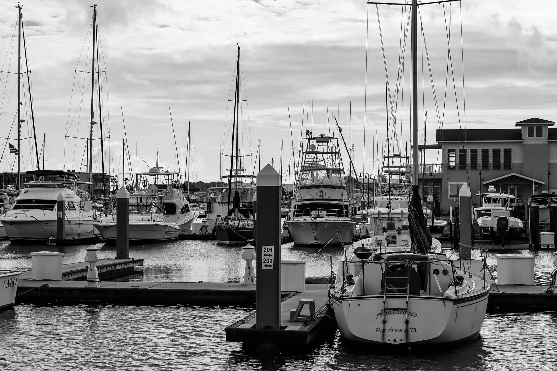 Marina with boats docked under a cloudy sky