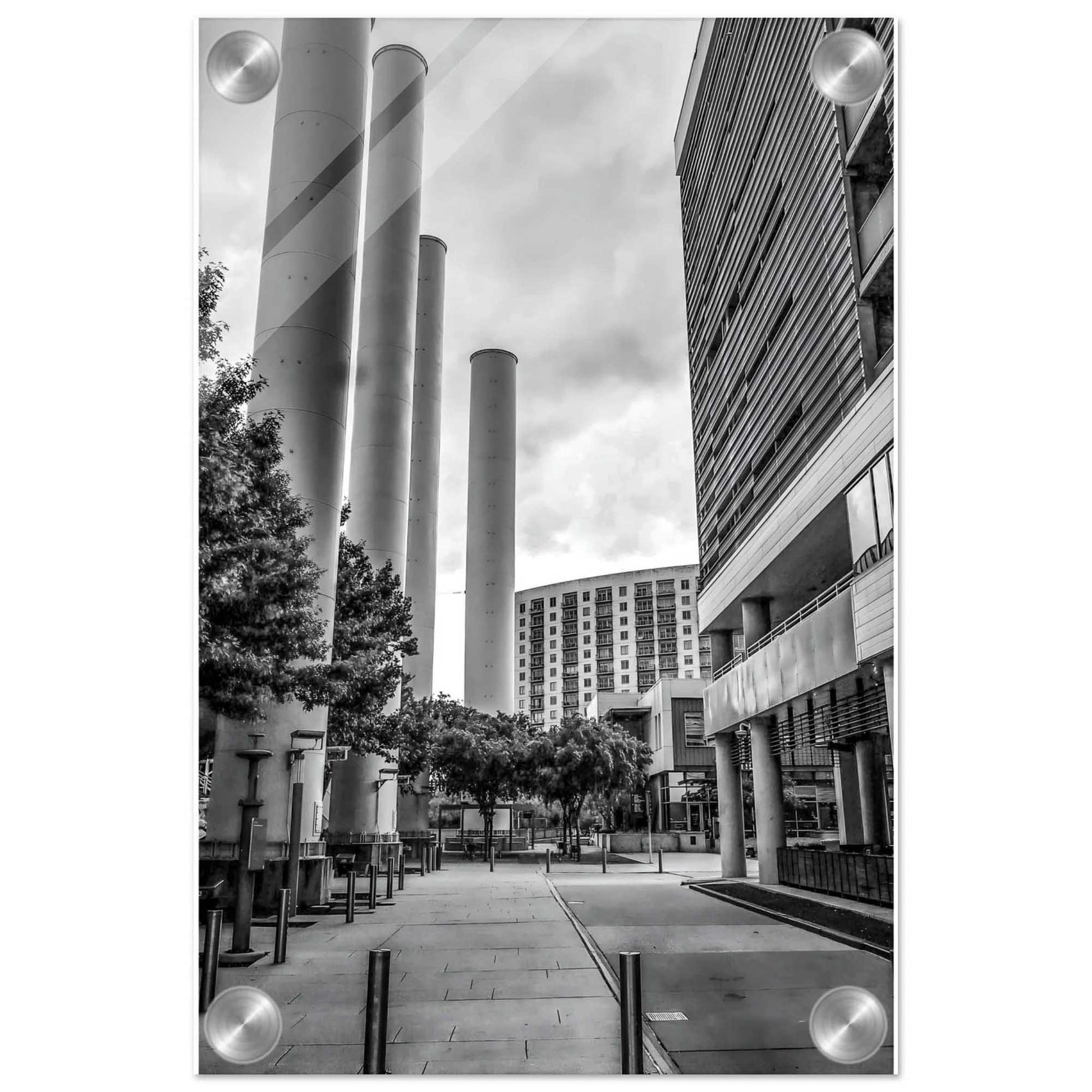 Black and white urban scene with modern buildings and cylindrical structures.