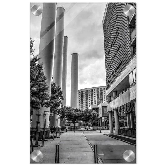 Black and white urban scene with modern buildings and cylindrical structures.