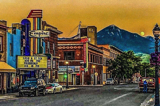 Artistic depiction of a small town street with mountains in the background