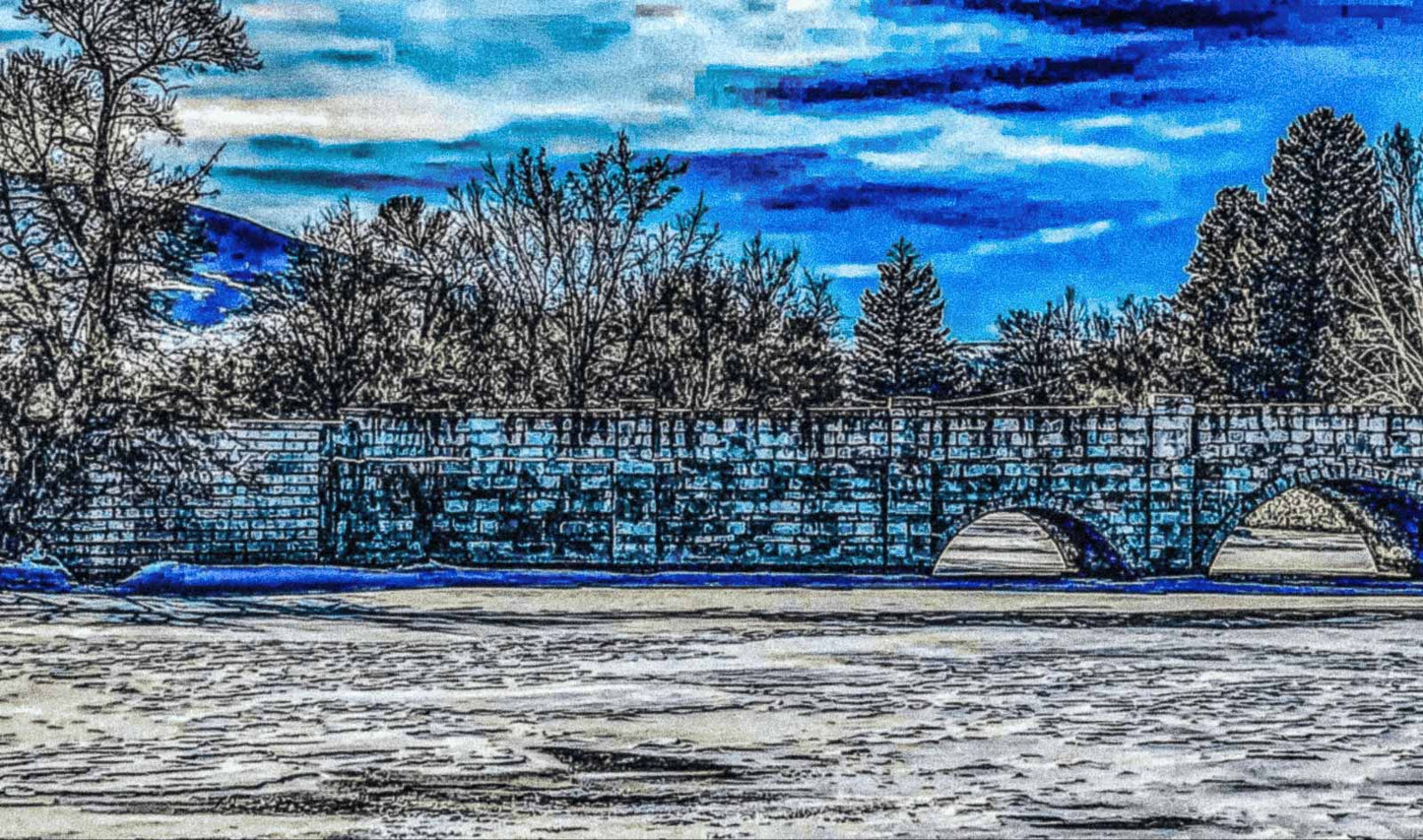 Stone bridge over a frozen river with trees and a blue sky in the background